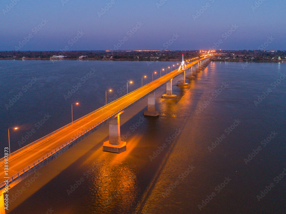 Obraz premium Aerial view of Bridge over khong river at night - bridge in the night of Second Thai–Lao Friendship Bridge. over the Mekong connects Mukdahan Province in Thailand with Savannakhet in Laos.