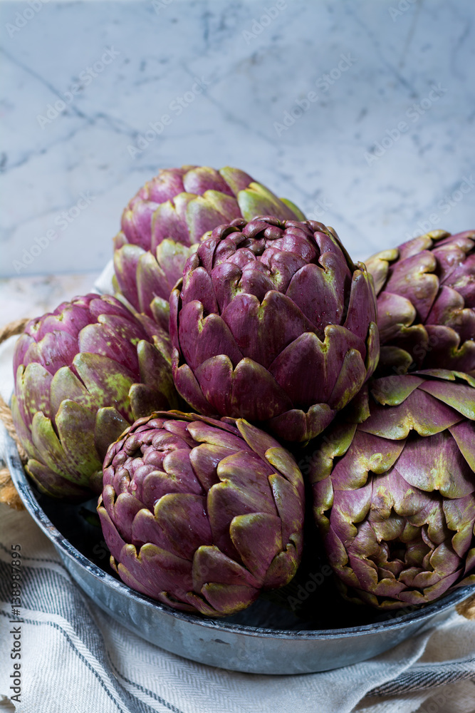 Obraz premium Fresh big Romanesco artichokes green-purple flower heads ready to cook