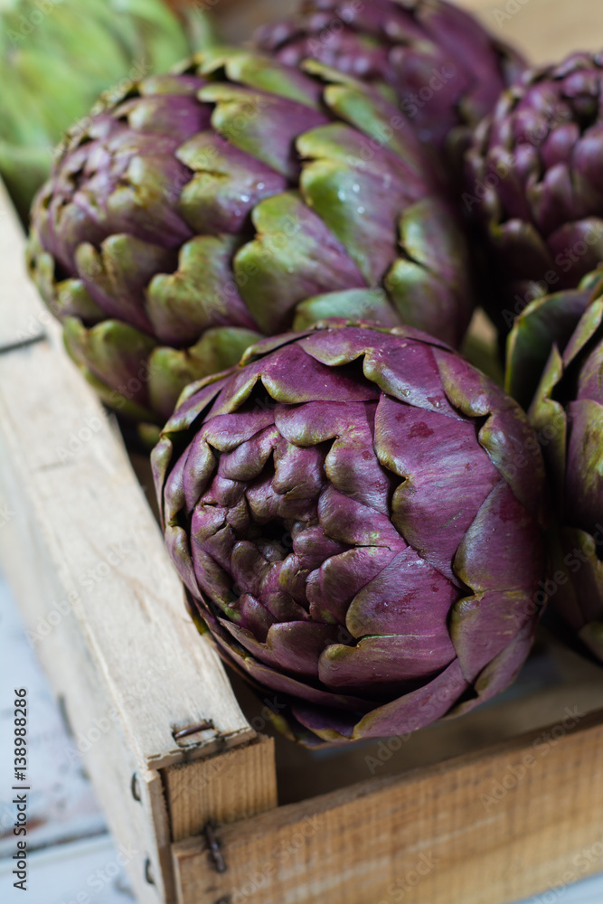 Fototapeta premium Fresh big Romanesco artichokes green-purple flower heads ready to cook