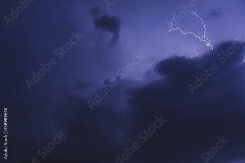 Thunderstorm, dark blue three-dimensional clouds illuminated by lightning flashes