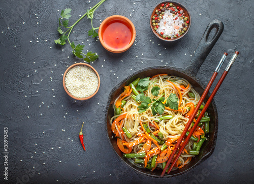 Starch (rice, potato) noodles with vegetables - bell peppers, carrots, green beans, onions, sesame seeds and soy sauce. Vegetarian dish. A delicious dinner in the Asian style