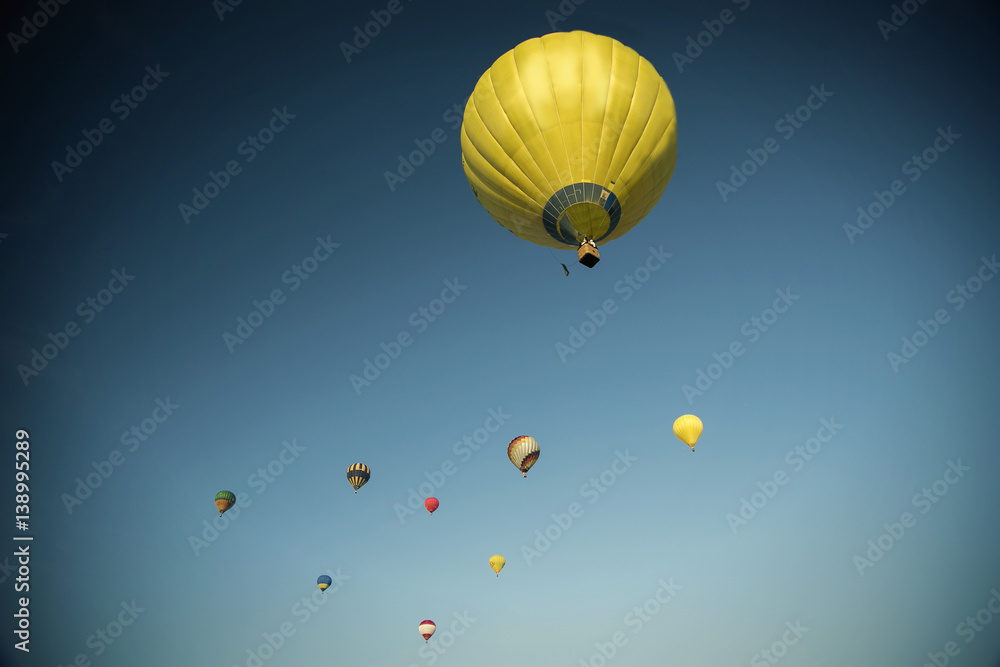 Fototapeta premium Start of big hot air balloons at the field with cool cloudy sky