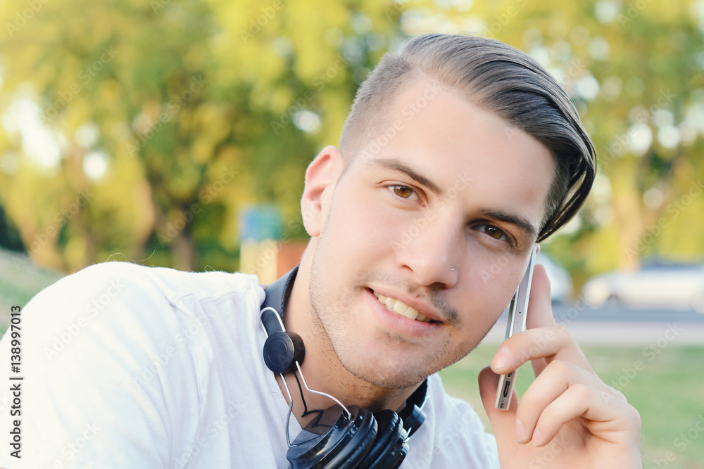 Young man talking on the phone. Outdoors. Young man talking on the phone. Outdoors.