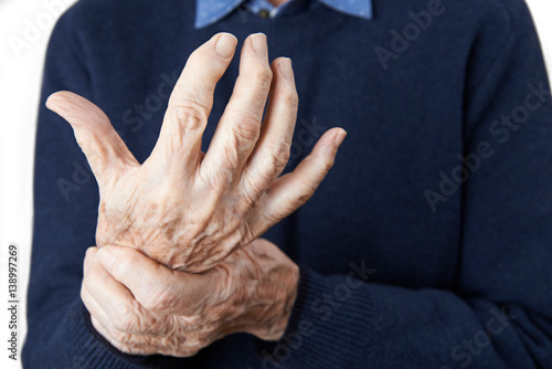 Close Up Of Senior Man Suffering With Arthritis photo