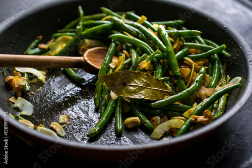Green beans with coconut chips and mustard seeds, in pan