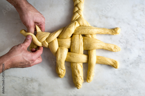 Person making orange olive oil challah bread, close-up