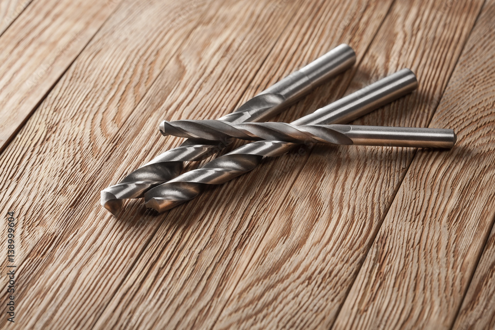 set of different drill bits on wooden background set of different drill bits on wooden background