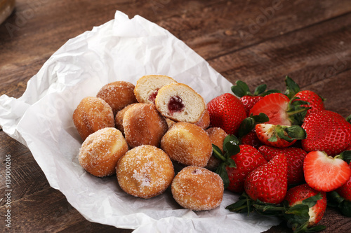 Bomboloni - traditional Italian doughnuts stuffed with strawberry jam photo