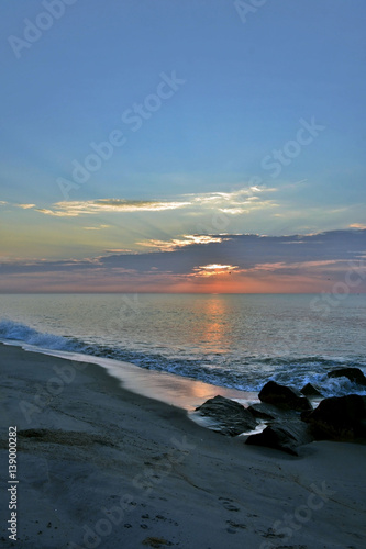 Scenic Summer Seashore Sunrise Over Rock Jetty on the Beach