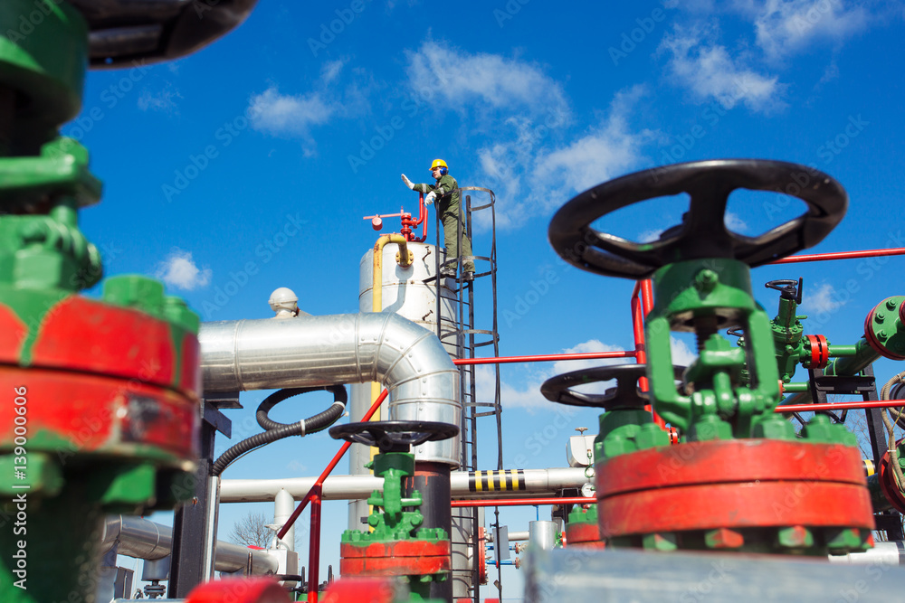 Oil and gas worker inside large petrochemical oil refinery Oil and gas worker inside large petrochemical oil refinery
