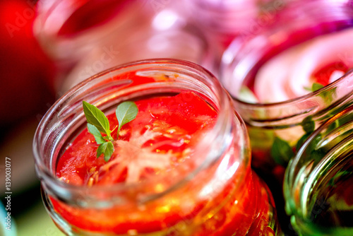 Wallpaper Mural Canning fresh tomatoes with onions for winter in jelly marinade. Macro shot of basil leaves on top of a red ripe tomato slice being put in jar. Torontodigital.ca