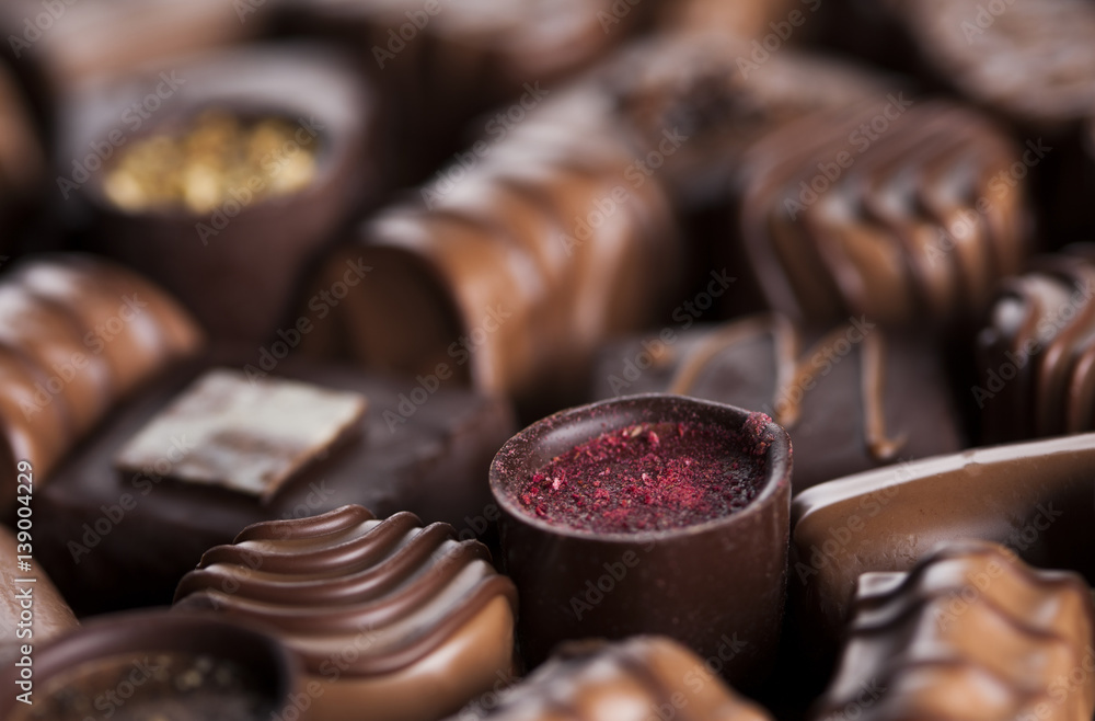 Chocolate bars and pralines on wooden background Chocolate bars and pralines on wooden background