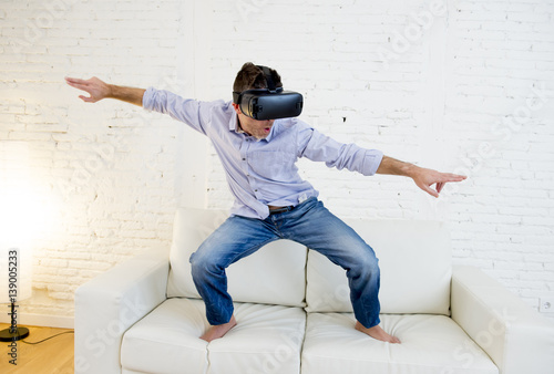 Photography happy man at home living room sofa couch excited using 3d goggles virtual realit