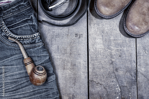 Wooden pipe for smoking on blue jeans, photo