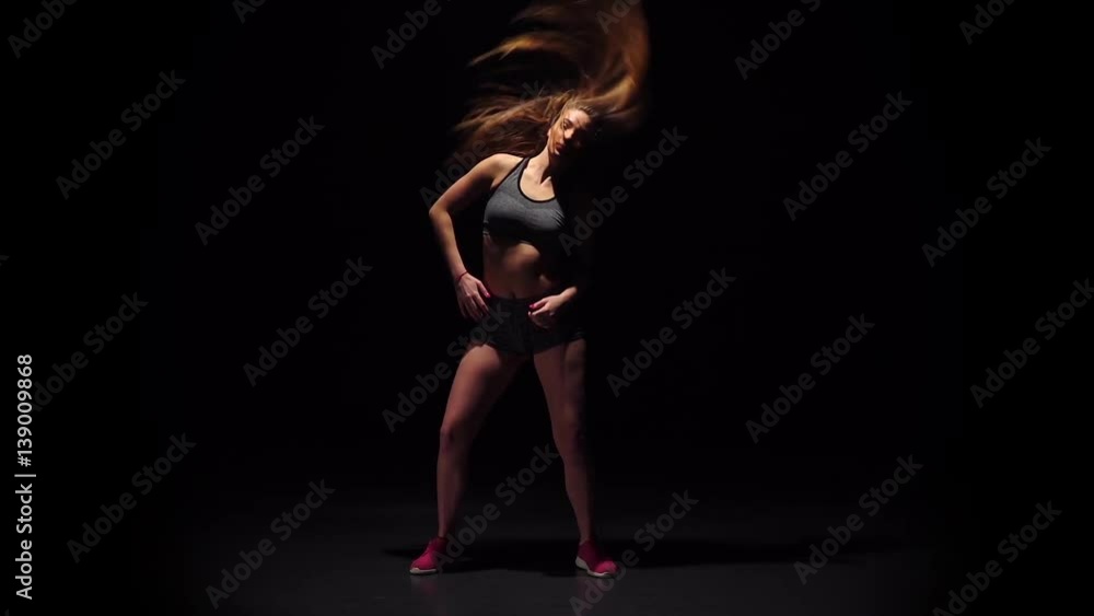 Girl dancing hip-hop movement in dark studio. Slow motion Girl dancing hip-hop movement in dark studio. Slow motion