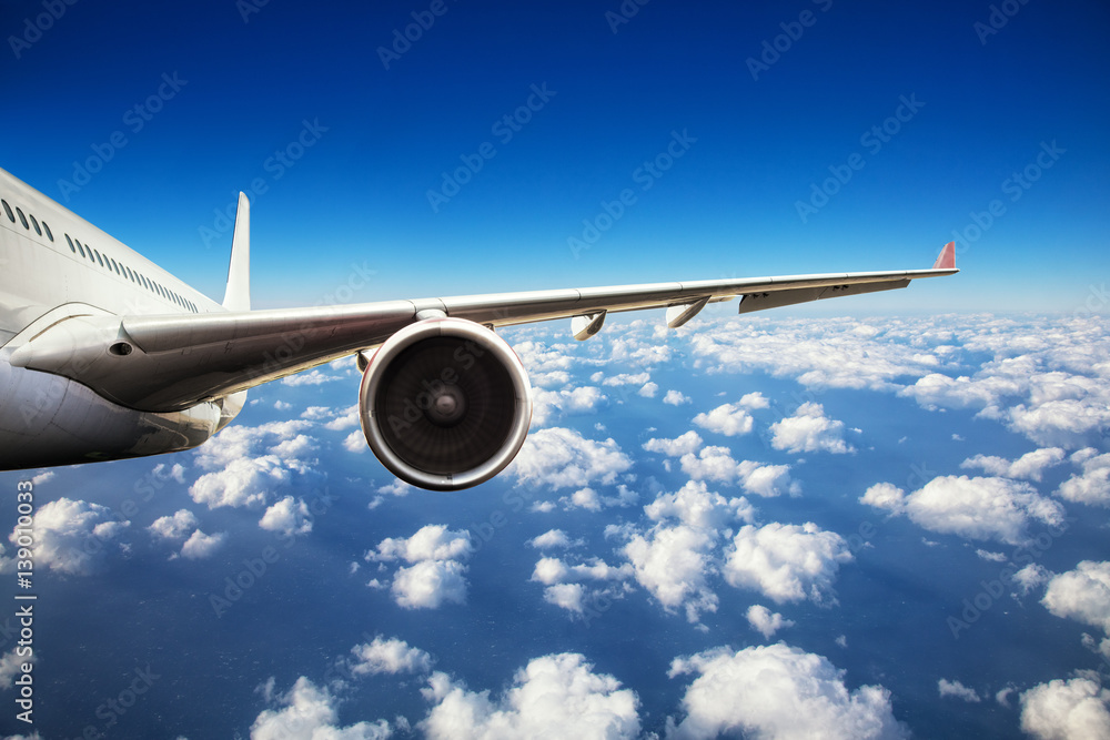 Obraz premium Close-up of passenger airplane flying above clouds