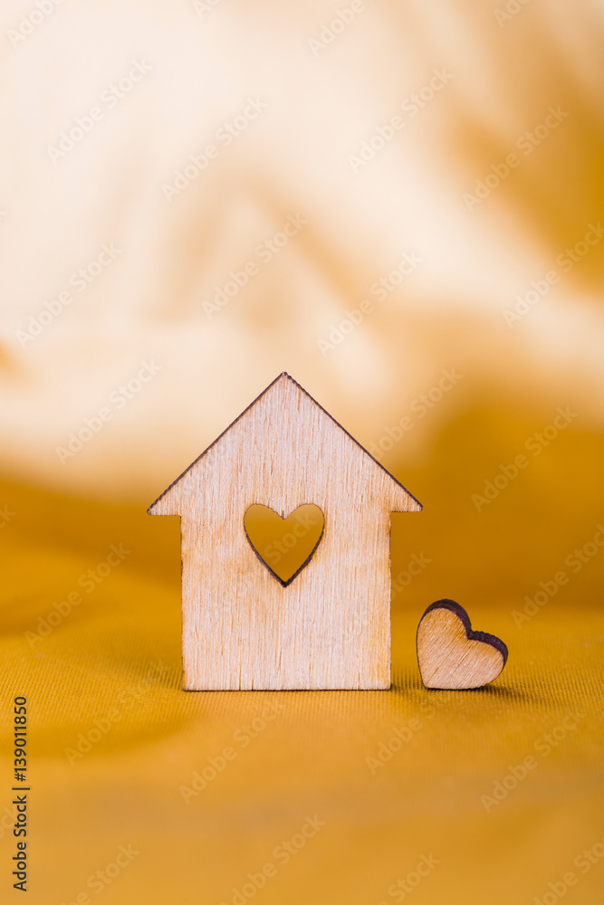Φωτογραφία Wooden house with hole in form of heart on golden satin fabric