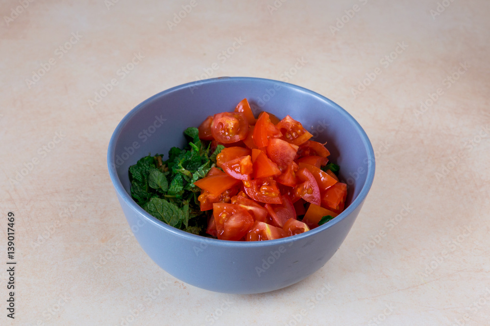 Cooking Tabbouleh salad. Chopped mint, tomatoes, green onions, parsley Cooking Tabbouleh salad. Chopped mint, tomatoes, green onions, parsley
