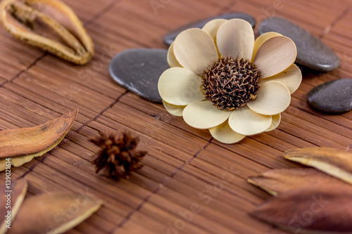 Dried flower and stones on wooden mat