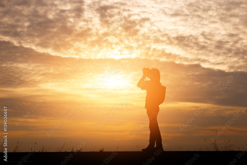 Silhouette woman shooting landscape photo