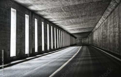 Asphalt road in empty tunnel with turn