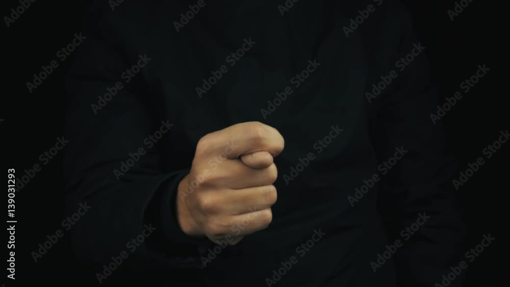 Caucasian male hand in long sleeve jacket making obscene shysh sign gesture on black background, close up isolated Caucasian male hand in long sleeve jacket making obscene shysh sign gesture on black background, close up isolated