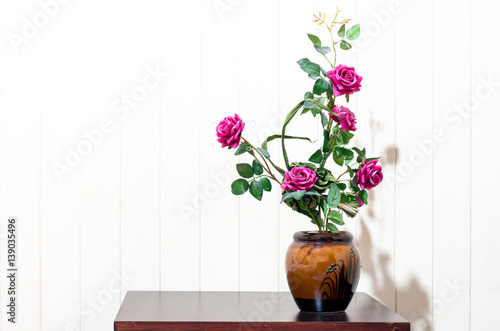 artificial rose Floral Bouquet Flower vase on wood table in white wooden background © tumsubin