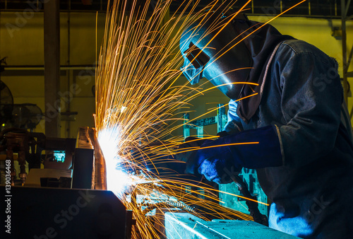 Worker,welding in a car factory with sparks, manufacturing, industry 