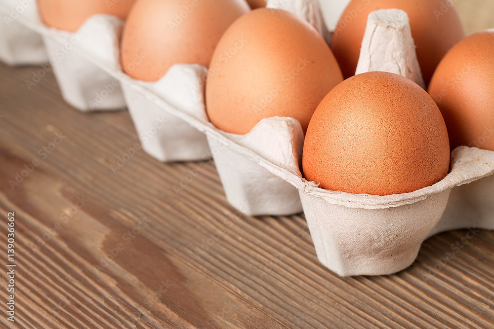 Eight eggs in box on a wooden table Eight eggs in box on a wooden table