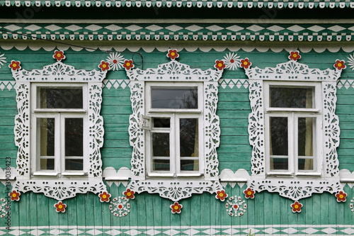 Richly decorated ornamental carved windows, frames on Lobanov's vintage wooden rural house in Leshkovo village, Sergiyev Posad district, Russia. Russian traditional national folk style in architecture photo