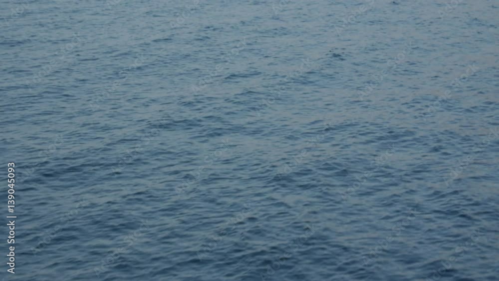 Blurry water waves with surface reflecting the sunshine background - view from moving boat. Blurry water waves with surface reflecting the sunshine background - view from moving boat.