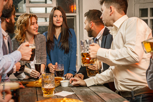 Group of friends enjoying evening drinks with beer