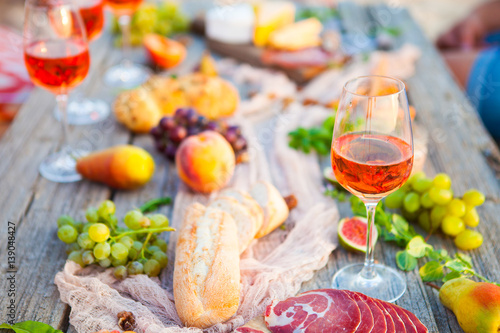 Picnic on the beach at sunset in boho style, food and drink concept photo