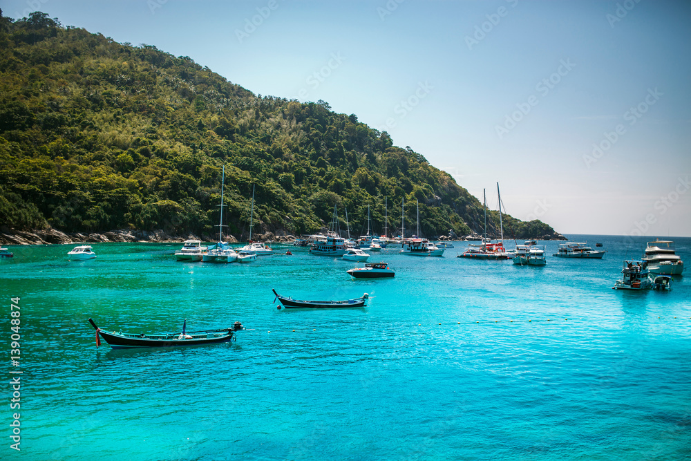 Landscape of many boats floating on the deep blue sea .