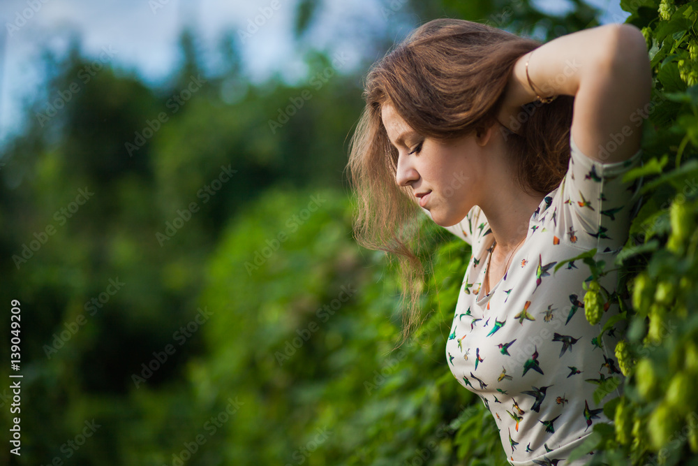 Young beautiful girl in fresh green branches of hop, closeup portrait, copy space for text Young beautiful girl in fresh green branches of hop, closeup portrait, copy space for text