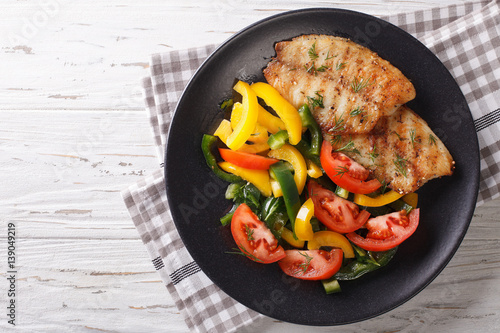 Slika na platnu Grilled fish steaks and fresh vegetable salad close-up