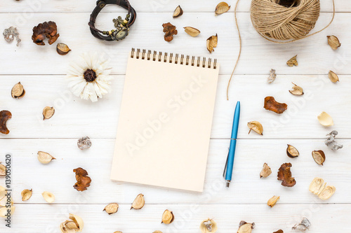 A blank notebook page and pen on white wooden table. Flat lay