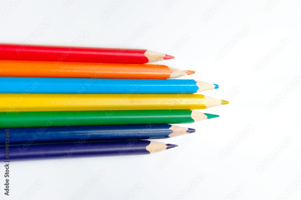 Fototapeta premium Heap of pencils of rainbow colors on the white surface.