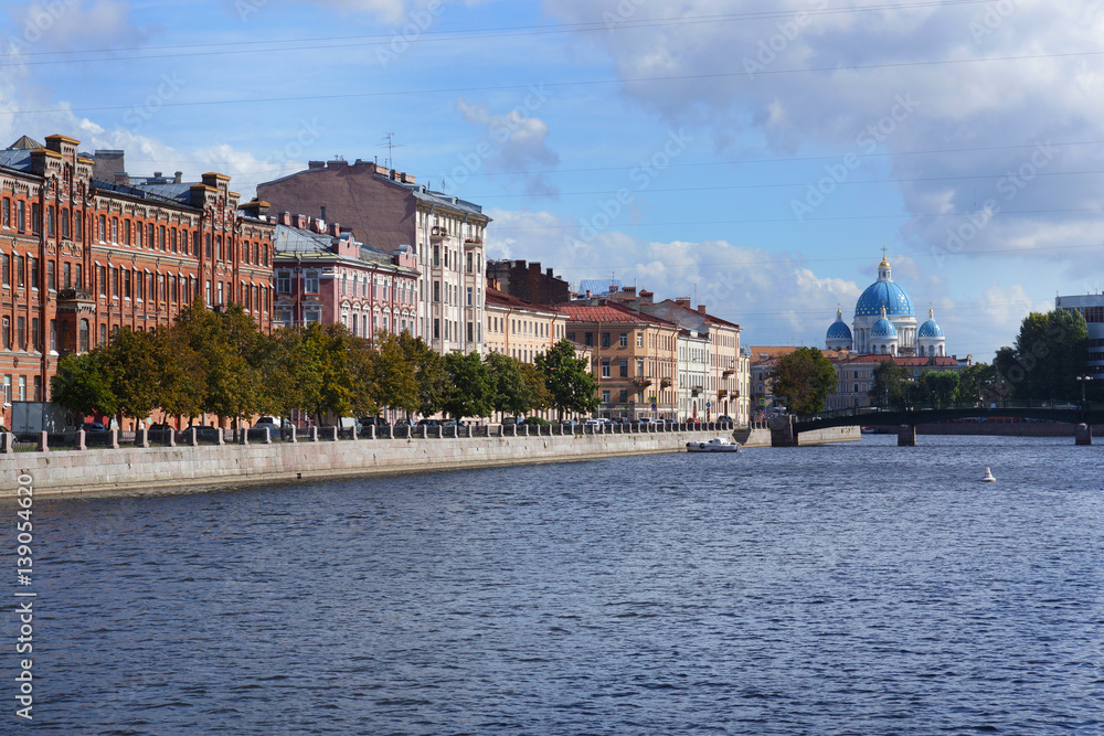 Obraz premium The granite embankment of the river, the house and the Cathedral on the other side