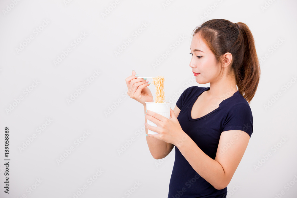 Young beautiful asian girl eating instant noodle using plastic fork. Young beautiful asian girl eating instant noodle using plastic fork.
