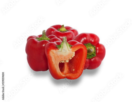 Several ripe red peppers, one of which is cut in half