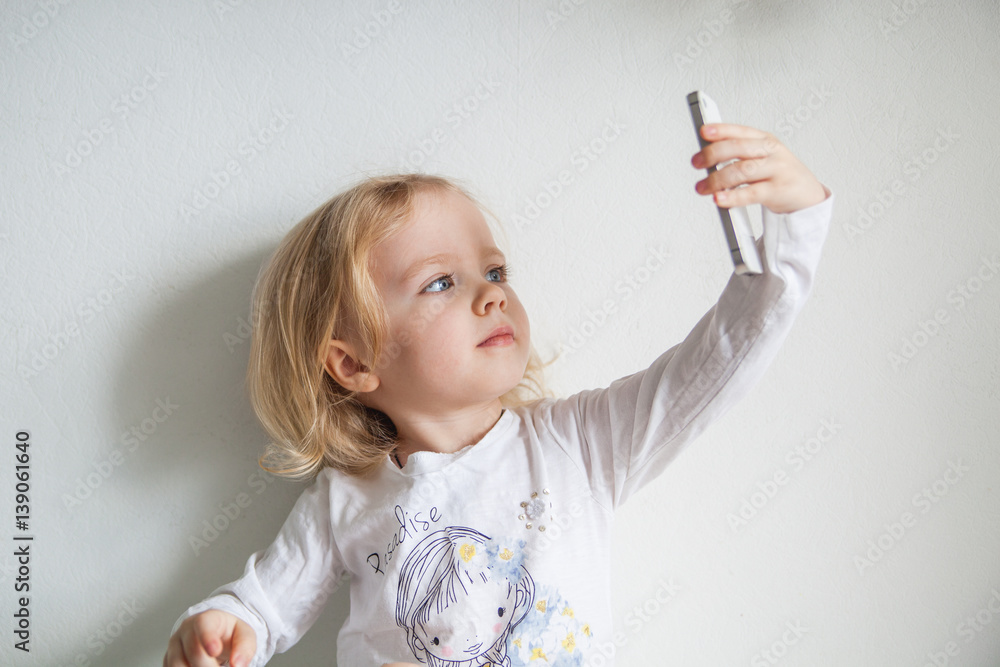 beautiful little girl with a smartphone makes selfie beautiful little girl with a smartphone makes selfie