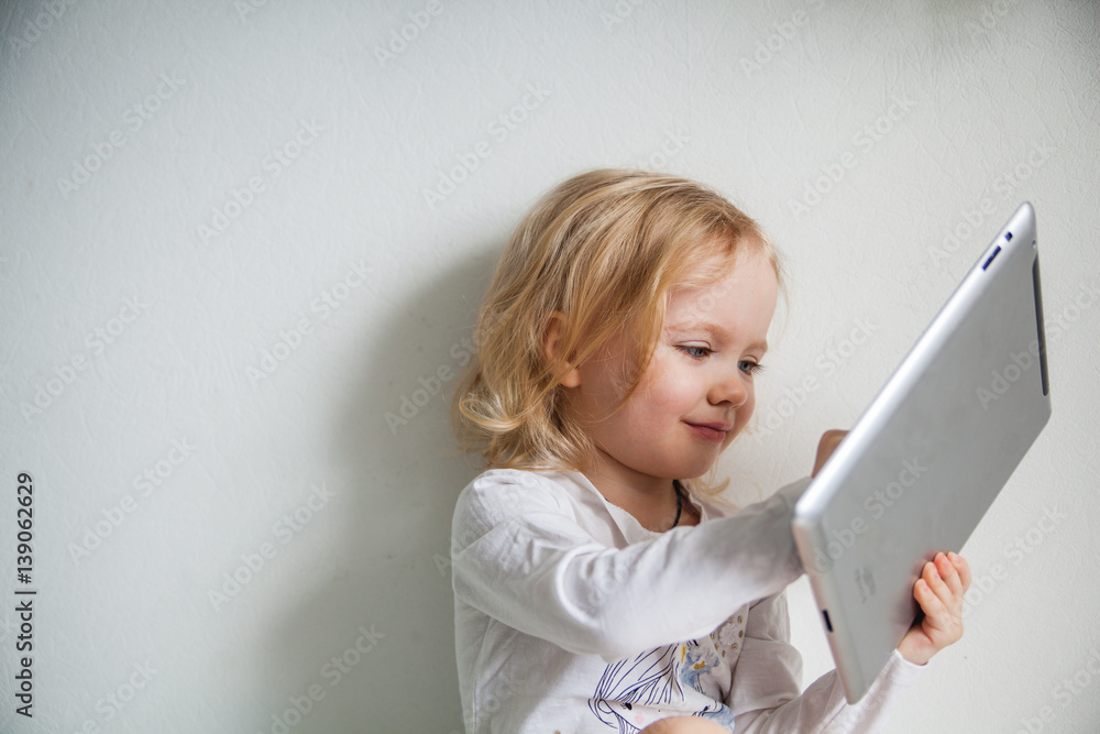 Fototapeta premium Pretty little girl with a Tablet PC. Isolated on white.