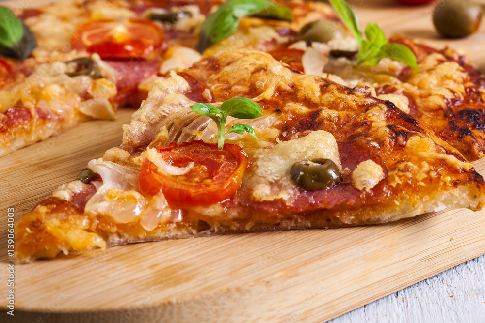 Slices of pizza with bacon, olives and tomatoes Slices of pizza with bacon, olives and tomatoes