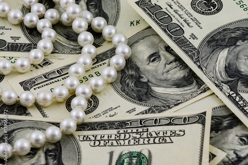 Wealth concept, US dollar banknotes and real pearls