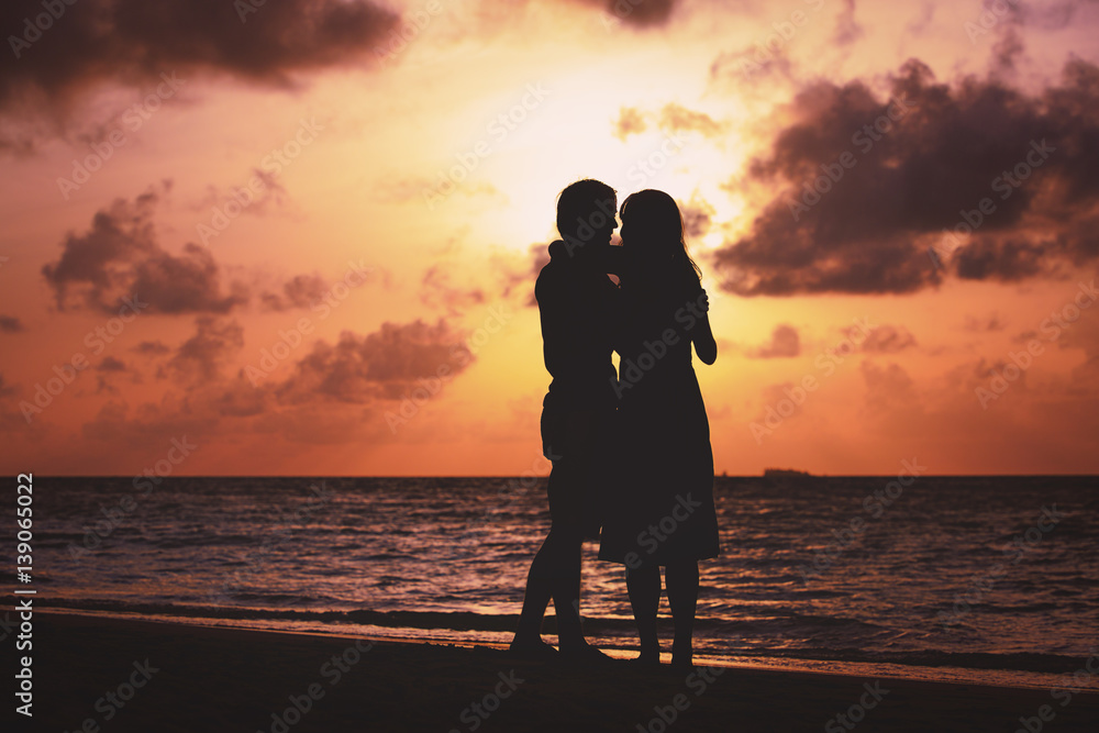 young romantic loving couple hug at sunset beach