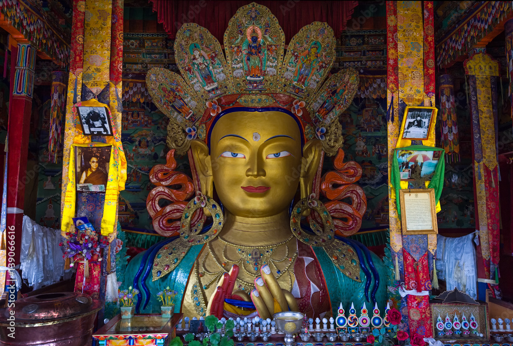 LEH, INDIA - MAY 9, 2015: Image of Lord Buddha in Thiksay Tibetan Buddhist monastery, located on top of a hill in Thiksey village, near Leh in Ladakh, India. Visitors reguraly come to pray here.