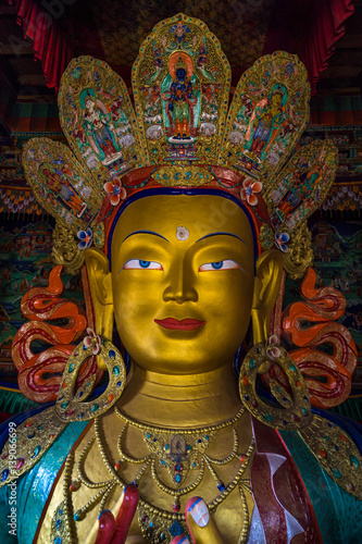 LEH, INDIA - MAY 9, 2015: Image of Lord Buddha in Thiksay Tibetan Buddhist monastery, located on top of a hill in Thiksey village, near Leh in Ladakh, India. Visitors reguraly come to pray here.