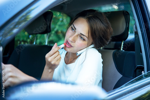 busy girl with lipstick and phone while driving