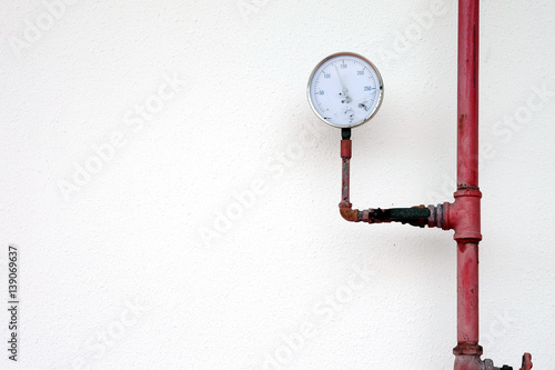 Pressure gauge and water pipe valve water on white wall